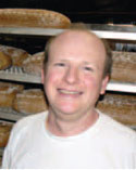 Ein Mann vor einem Regal mit Broten