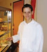 Fotographie eines jungen Mannes vor einer Essensausgabe
