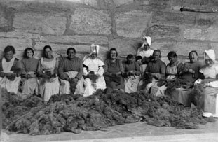 Fotographie einer Gruppe von Frauen beim Reinigen von Wolle