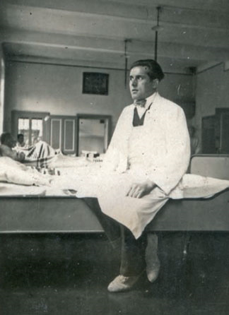 Foto des Pflegers Andreas Junker sitzend auf einem
Patientenbett.
