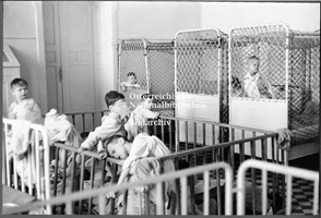 Foto: Kinder in Gitterbetten