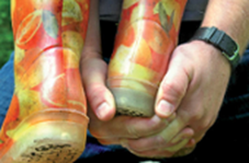 Das Foto zeigt die Hände einer erwachsenen Person, die
für ein Kind in bunten Gummistiefeln die "Räuberleiter"
bilden.