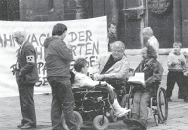 Fotografie in schwarz-weiß; Szene aus einer Mahnwache; vier
Menschen die sich beraten