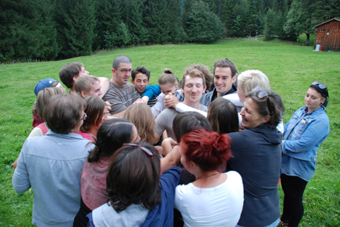 Foto einer Gruppe von Menschen die eng beieinander stehen.