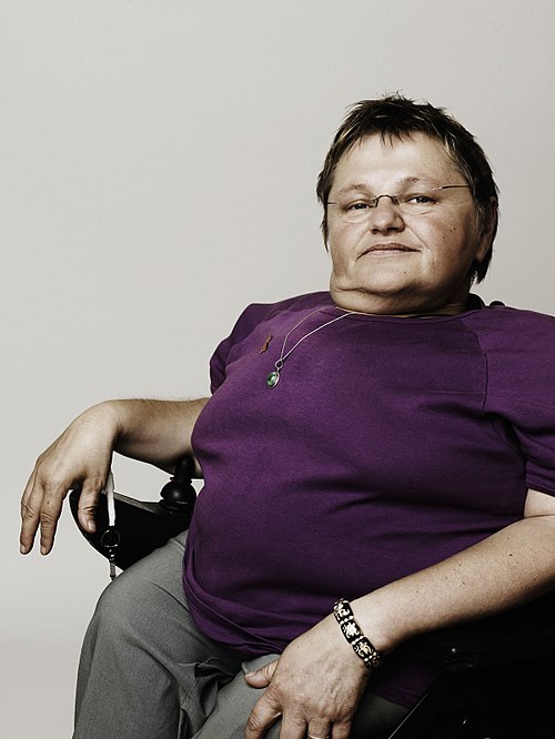 Theresia Haidlmayr trägt eine randlose Brille, ein violettes Shirt, eine Halskette und ein Armband. 