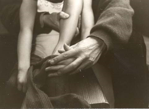 Eine Betreuerin sitzt mit einem Kind auf einer Bank und zieht ihm die Hose
                     an.