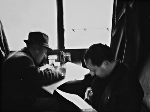 Foto von zwei Männern in einem Zug die ein Formular
ausfüllen