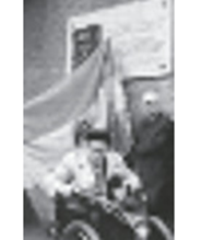 Fotografie in schwarz-weiß: Josef Gradl hält ein Mikrophone in der
Hand und hält eine Rede; dahinter steht ein zweiter Mann der eine Fahne
hält